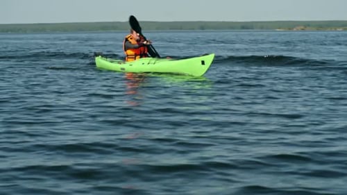 Young Man Kayaking on a Calm Lake