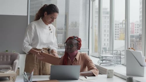 Two Multiethnic Women Working in Office