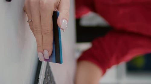 Typing on Laptop While Holding Credit Card Close Up