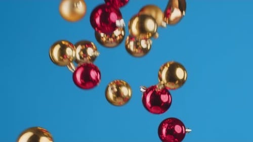 Fliegende Weihnachtskugeln vor blauem Hintergrund