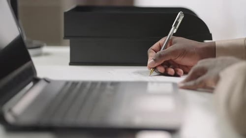 Writing on Paper at a Modern Workplace