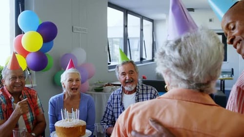 Mature Adults Celebrating Birthday Party Together Indoors