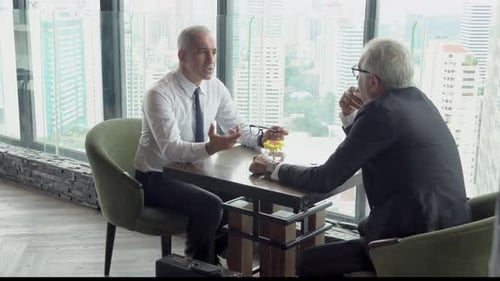 Zwei hochrangige Geschäftsleute diskutieren mit Partnerschaft über die Arbeit im Büro.