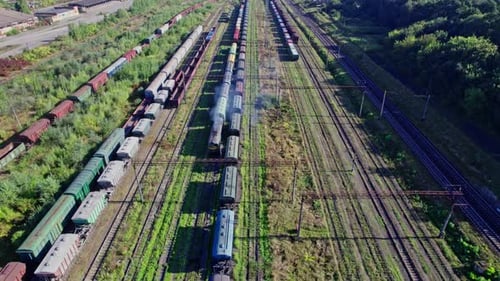 Aerial View of Moving Train in a Train Yard