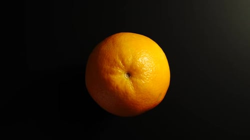 Single Orange Still Life on Black Background