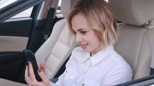 Woman Using Phone in Car Wearing White Shirt