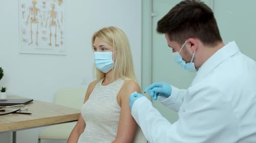Doctor Doing Vaccine Injection to a Female Patient in a Health Clinic