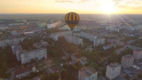 Blue-And-Yellow Air Balloon Flying Over Town at Dawn Towards Sun, Fantasies