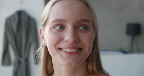 Smiling young woman looking at camera indoors