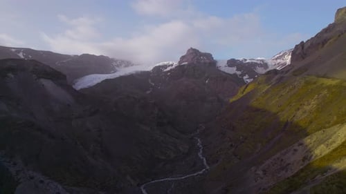 Aerial Breathtaking View of Mountains with Patches of Snow on Peak Against Sky