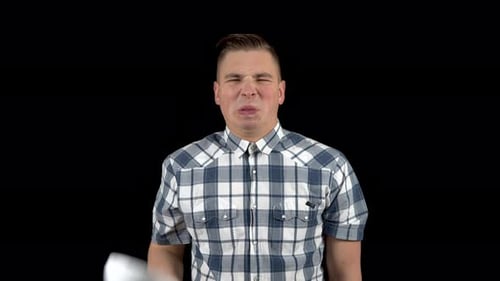 Un jeune homme enlève son masque et montre une émotion de dégoût sur son visage. L'homme est désagréable