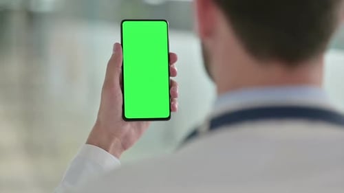 Doctor Using Smartphone with Green Screen in Hospital