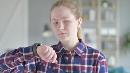 Young Woman Checks her Smart Watch Device