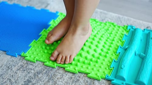 Close Up View of Little Girl Walks on a Massage Mat