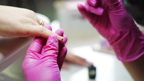 Nail Artist Applying Polish to Client's Fingernails