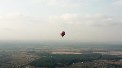 Hot Air Balloon Drifting Over Rural Landscape