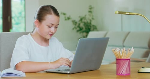 Girl Typing on Laptop Computer at Desk