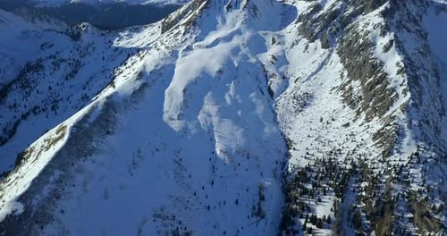 Aerial drone view of snow covered mountains in the winter.