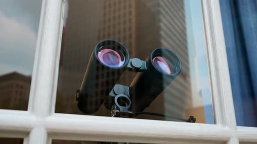Binoculars in a window. Spying technology. Spy gear. Observation equipment.