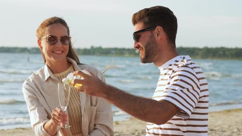 Happy Couple Drinking Champagne on Summer Beach