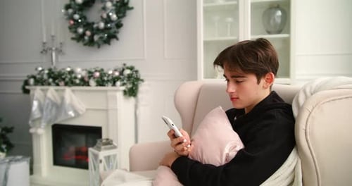 Teen Uses Phone in Festive Christmas Setting