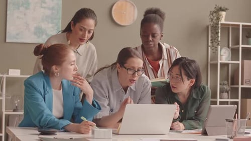 Women Collaborate on Laptop in Modern Office
