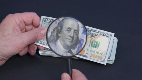 Close up of Hands Inspecting Hundred Dollar Bills