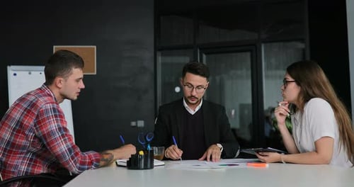 Creative Team of a Business Meeting in a Modern Starting Office Discussing Ideas for the Development