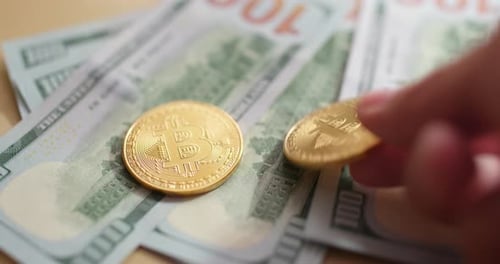 Bitcoins Placed on Pile of One Hundred Dollar Bills