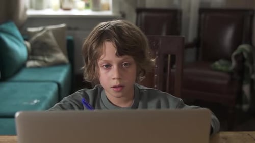 Child with Laptop Engaged in Education at Home