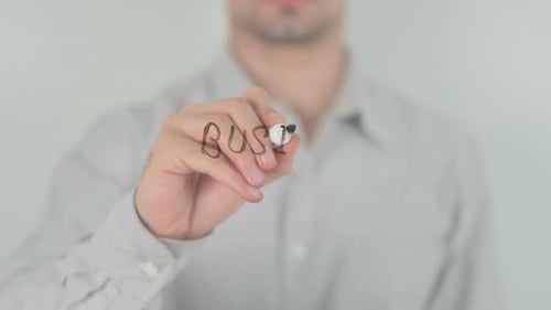 Man Writes "Business Development" on Glass Surface