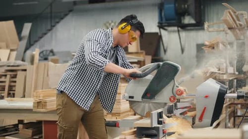 Woordworker Working with Electric Saw Busy Sawing Wood in Workshop