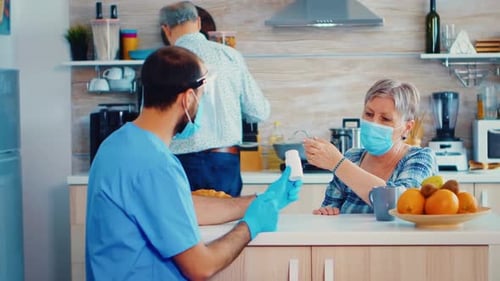 Home Healthcare Nurse Visiting Senior Woman in Kitchen