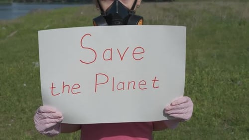 Child Holds Sign: Save the Planet, Wears Gas Mask