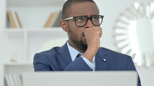 Man with Glasses Contemplating at Computer in Office
