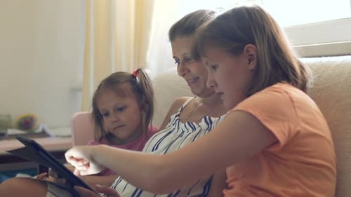 Mother and Children Enjoying Tablet Indoors