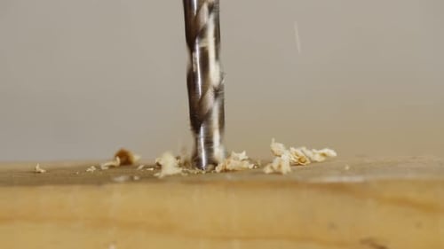 Drill Boring Into Tan Wooden Plank Close Up