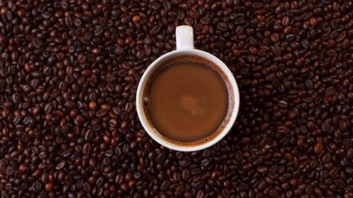 Top View of White Cup of Black Coffe on Coffee Beans