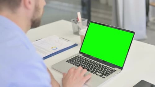 Typing on Laptop with Green Screen in Office