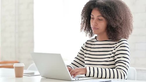 Woman Works on Laptop in Bright Modern Office
