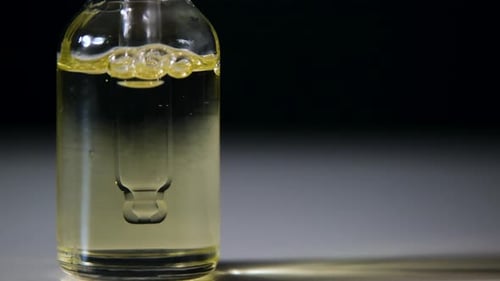 Liquid Droplets Forming Bubbles in Medicine Bottle