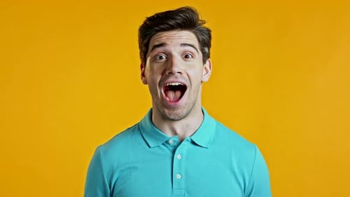 Man Expressing Surprise and Joy on Yellow Background