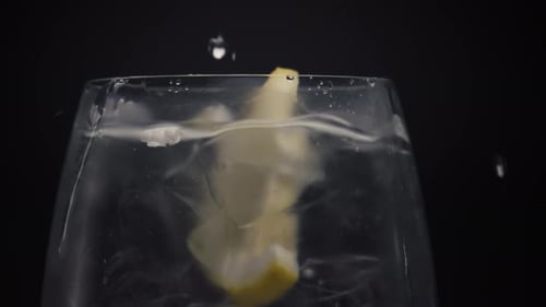 Lemon Slice Splashing into a Glass of Water