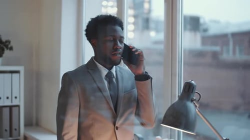 Young Black Businessman Having Phone Conversation in Modern Office