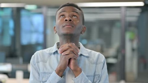 Young Adult Clasping Hands in Prayer or Contemplation