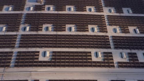 Aerial shot of solar panels covers the roof of a large building