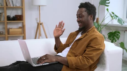Man Video Conferencing on Laptop at Home
