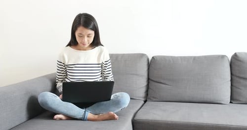 Woman Working on Laptop, Sitting on Sofa