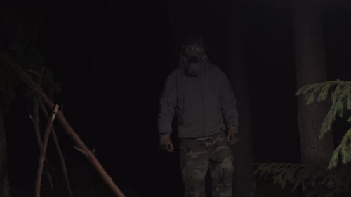 Man in a Gas Mask Escapes From Coronavirus in the Woods at Night