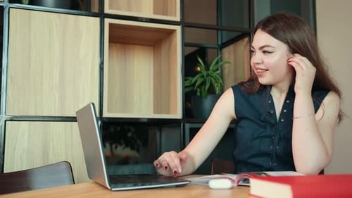 Smiling Woman Working at a Desk in an Office